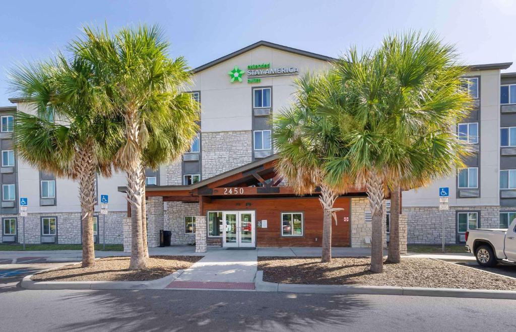 a hotel with two palm trees in front of it at Extended Stay America Select Suites - Tampa - Brandon - East in Tampa