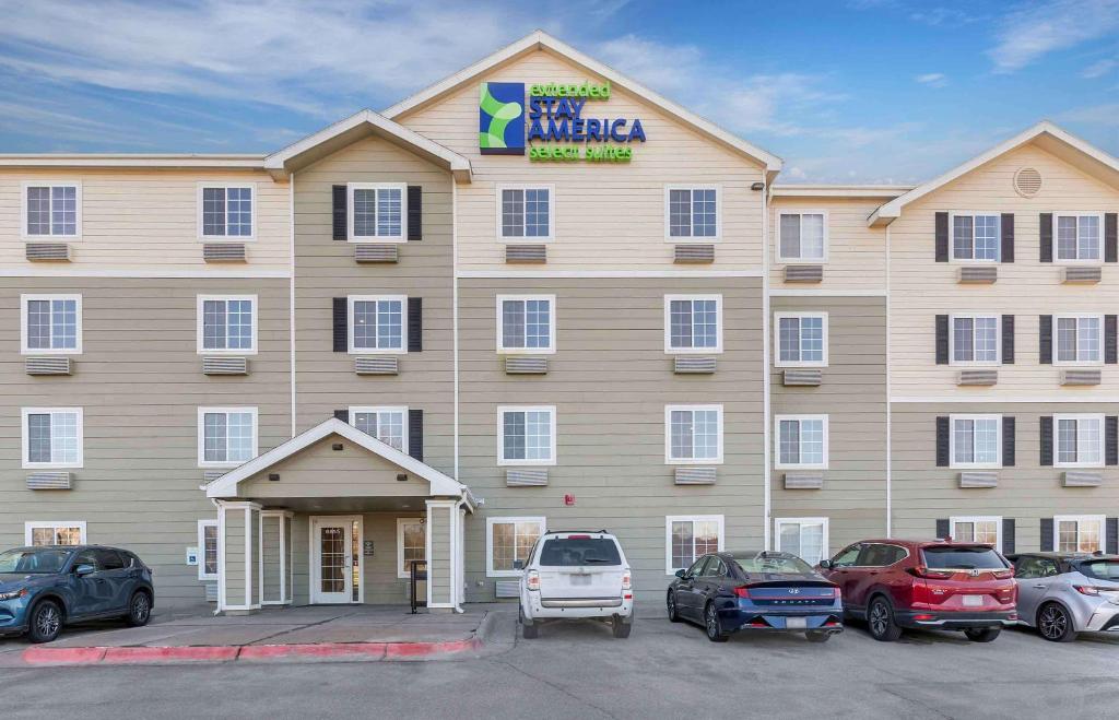 Un gran edificio con coches aparcados delante. en Extended Stay America Select Suites - Omaha - Southwest, en Omaha