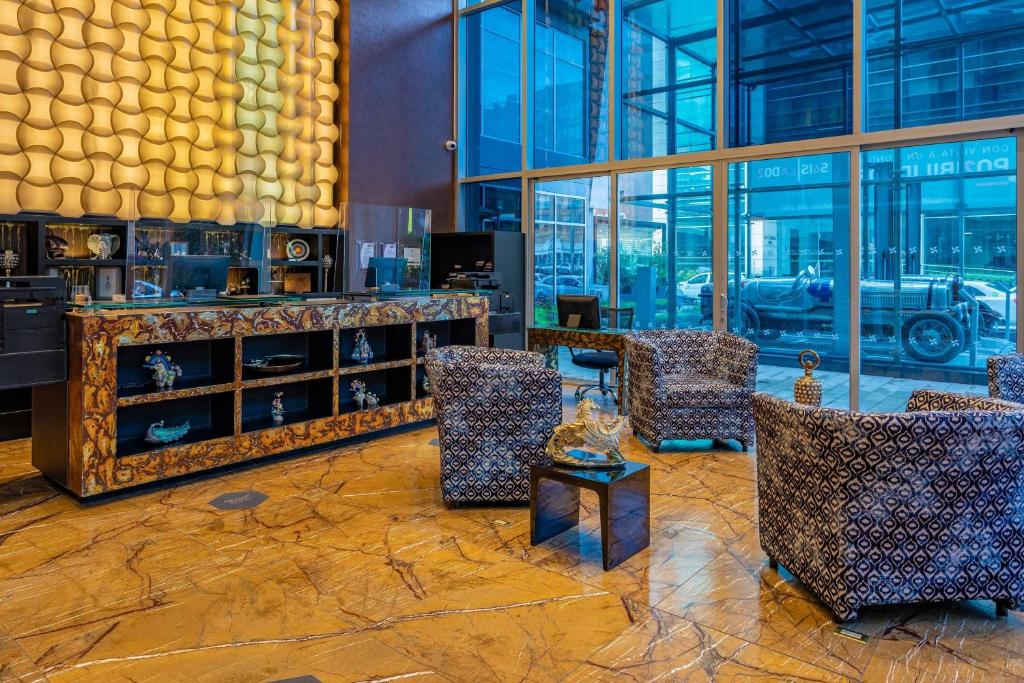 a lobby with chairs and a table and windows at Four Points By Sheraton Bogota in Bogotá