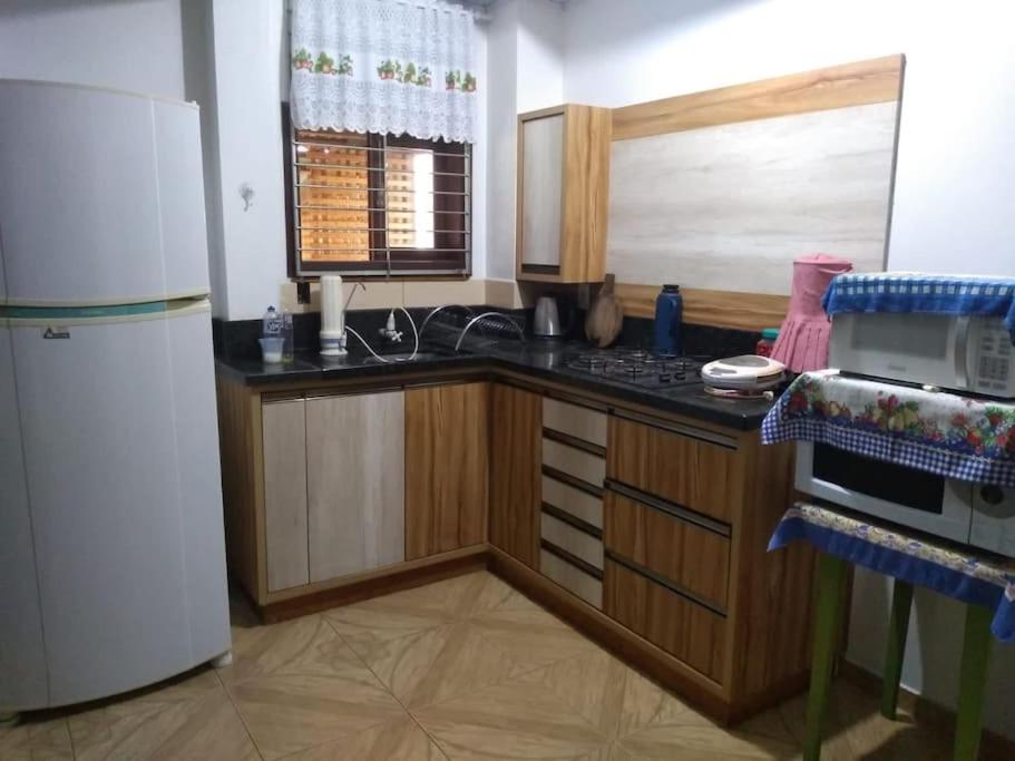a kitchen with a refrigerator and a counter top at Casa agradável in Indaial