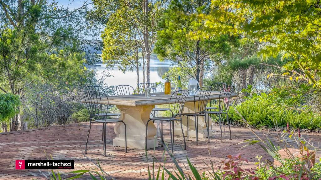 une table avec des chaises autour dans un parc dans l'établissement Bermagui Jewel on the Lake Cuttagee Bermagui Wifi provided, à Bermagui