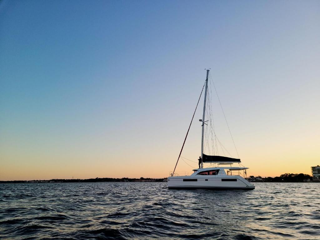 a white sailboat on the water at sunset at Florida Sail - Custom Sail Experiences in St Pete Beach
