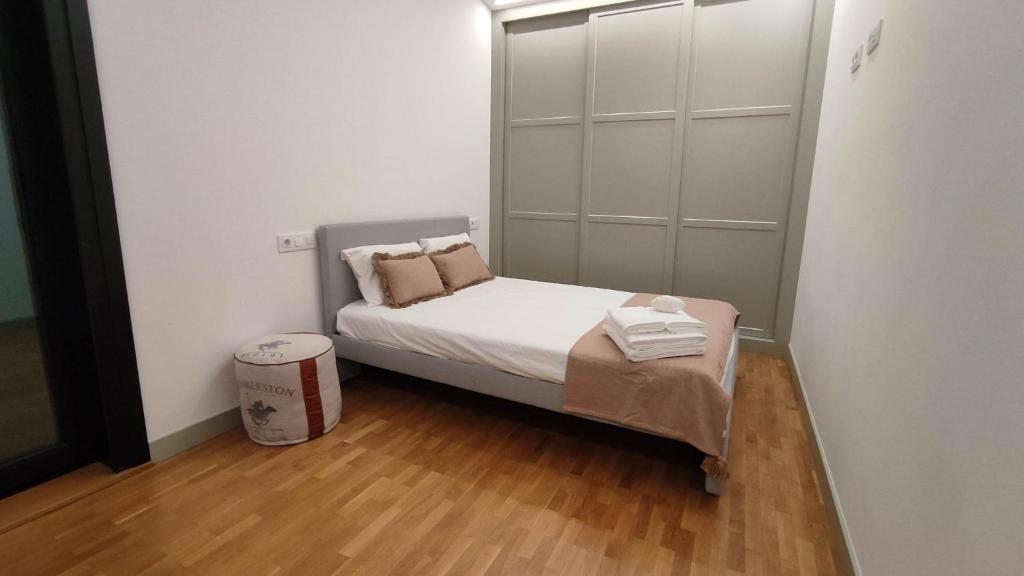 a small bedroom with a small bed and wooden floors at Dorneda 57 in Oleiros