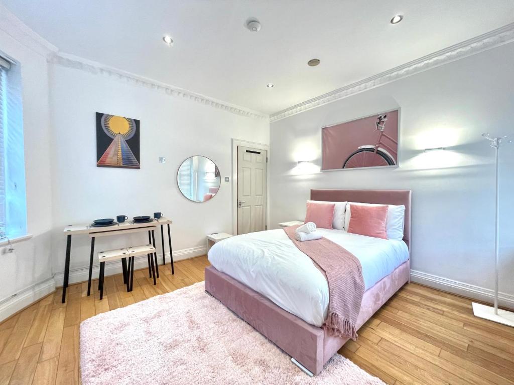 1 dormitorio con cama, mesa y espejo en Hyde Park Corner House en Londres