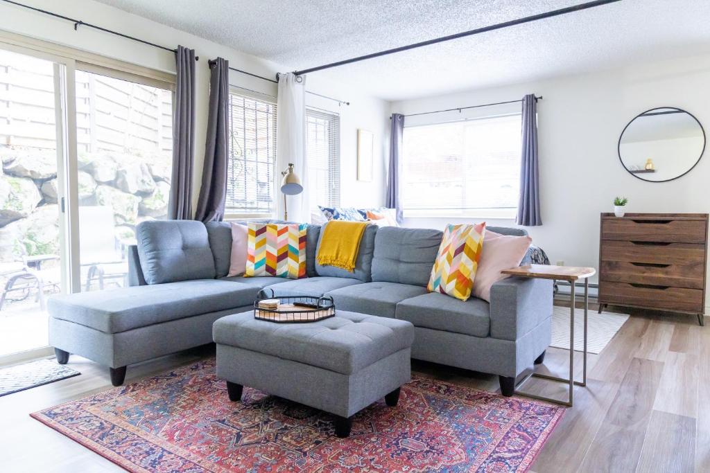 uma sala de estar com um sofá azul e um tapete em King Bed + Studio! Free Parking, Patio, WFH Space! em Seattle