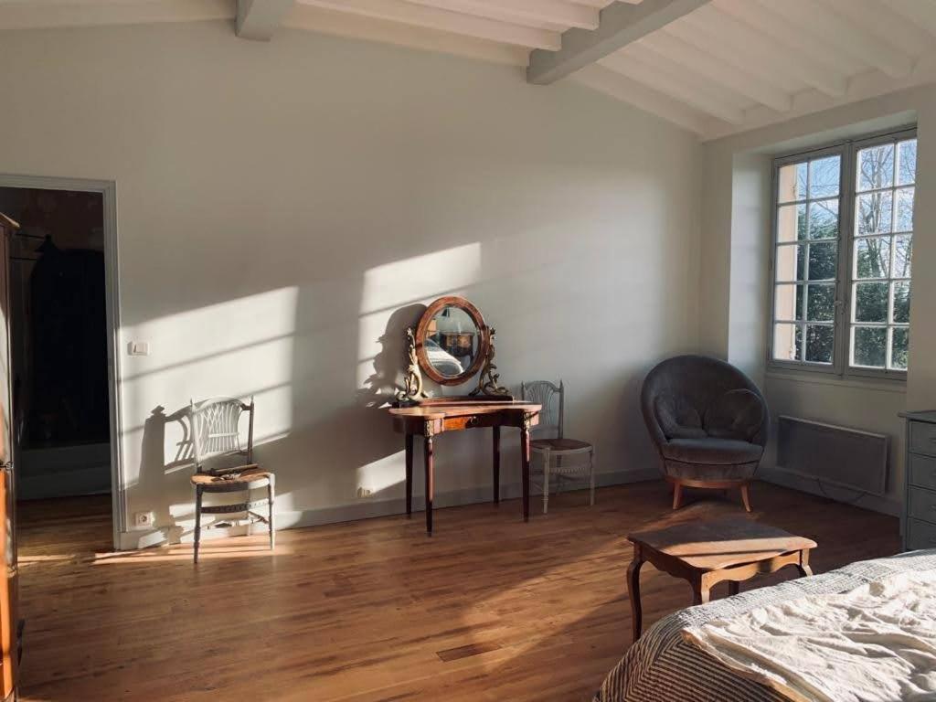 - une chambre avec un miroir et une table avec une chaise dans l'établissement Bourg sur Gironde, à Bourg