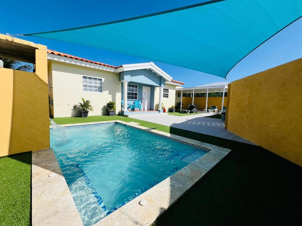 una piscina frente a una casa en The Gold Vacation Villa en Santa Cruz