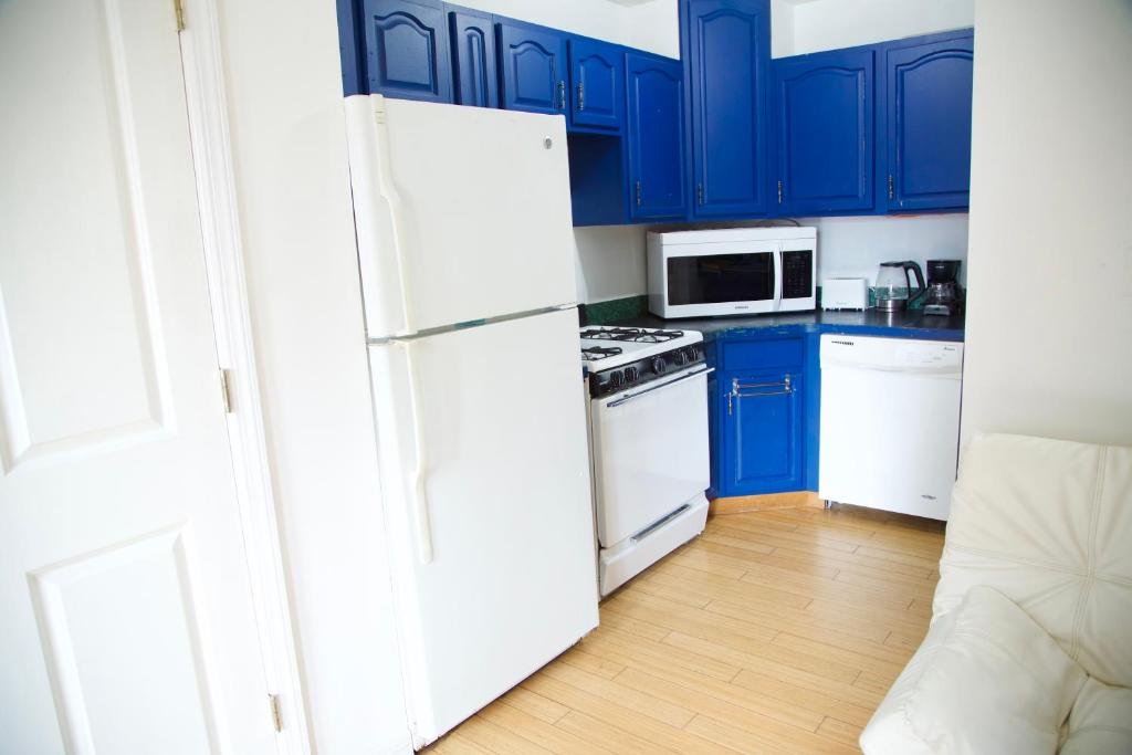 a kitchen with blue cabinets and a white refrigerator at BrightonBeach-Big Room3-5m to Ocean in Brooklyn