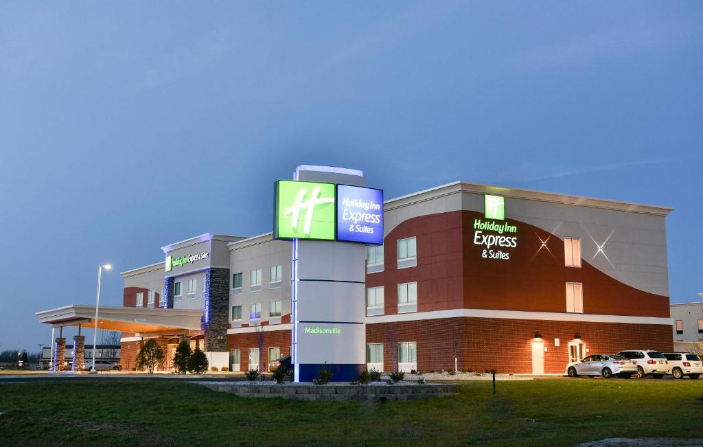 麥迪遜維爾的住宿－Holiday Inn Express & Suites - Madisonville, an IHG Hotel，前面有标志的大建筑