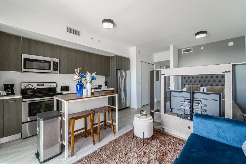 a kitchen and living room with a blue couch at Devereaux Miami Luxury One-Bedroom and Studios in Miami