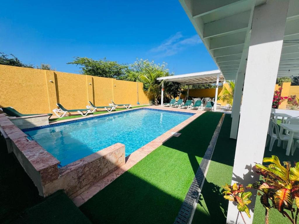 una piscina con tumbonas junto a una casa en The Gold Vacation Apartments en Santa Cruz