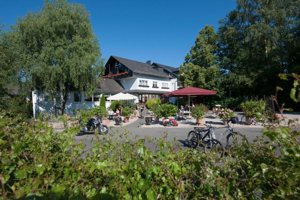a house with bikes parked in front of it at Landidyll Hotel Restaurant Birkenhof in Klosterkumbd