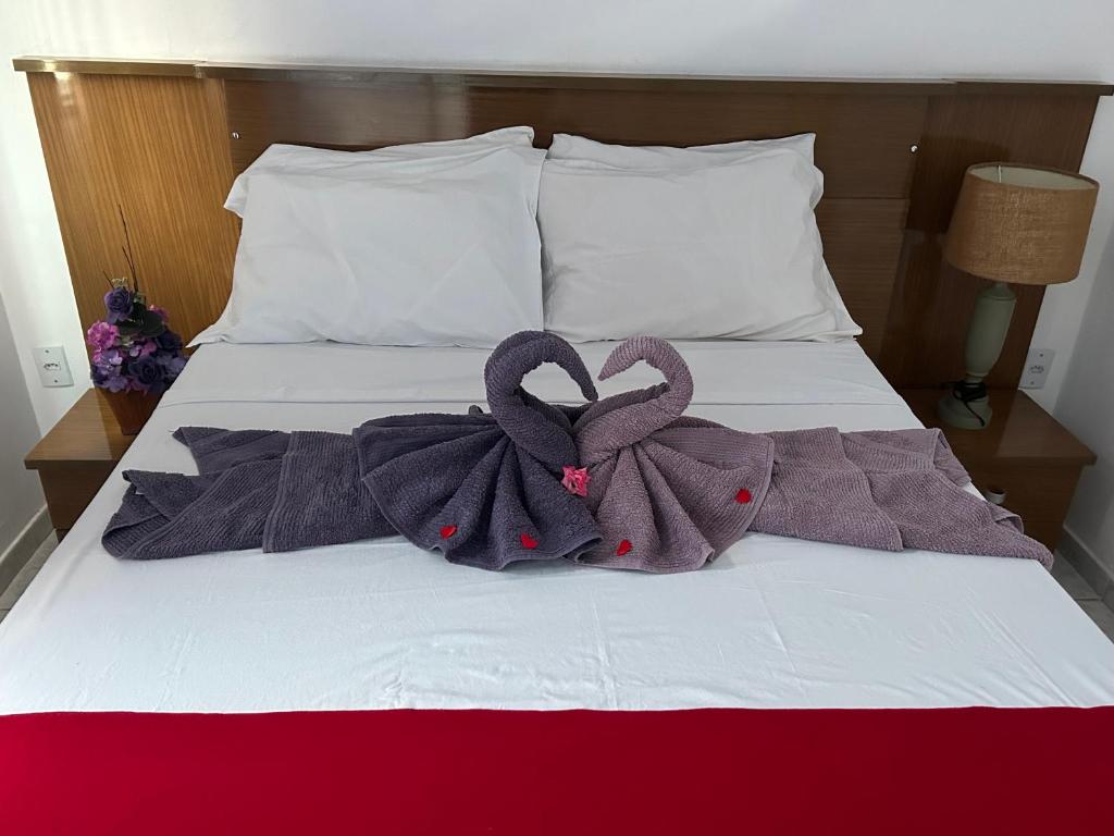 a bed with two towels and two hearts at Apartamento Quarto e Sala Mobiliado in Vila Velha