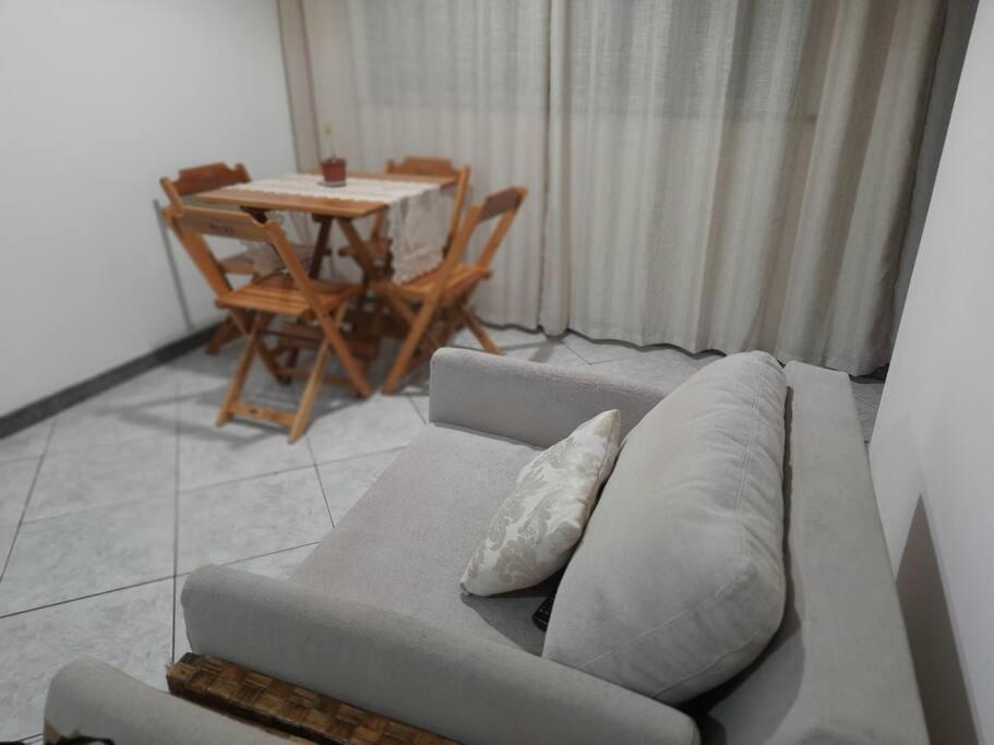 ein Wohnzimmer mit einem Sofa und einem Tisch in der Unterkunft Apartamento perto da Orla de Atalaia in Aracaju