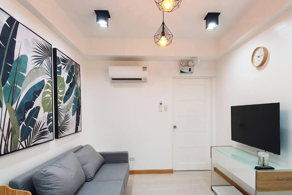 a living room with a couch and a tv at Travelers Inn - Cozy Capsule Bunks, Makati in Manila