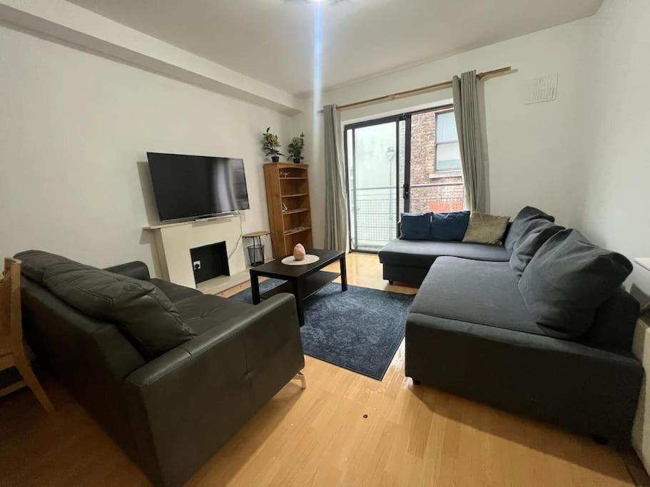 a living room with two couches and a television at The Flat in Temple Bar in Dublin