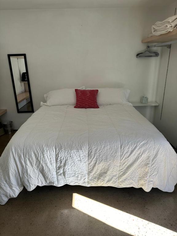 - un grand lit blanc avec un oreiller rouge dans l'établissement Tropical Oasis On The Water Crown Point, à San Diego