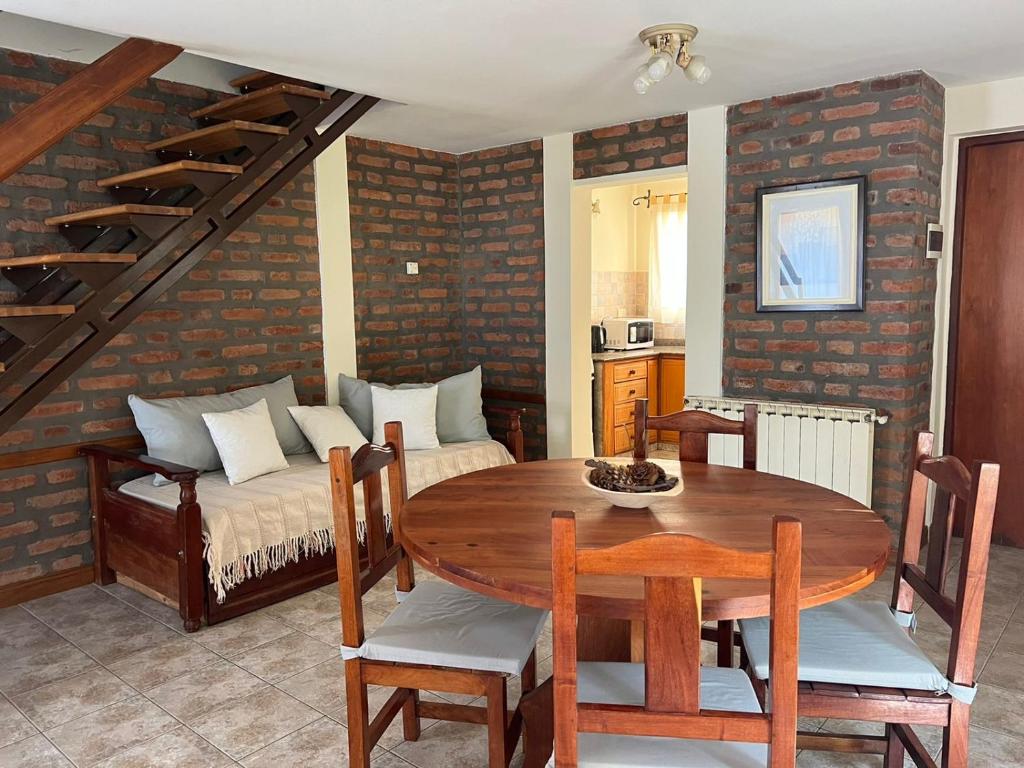 sala de estar con mesa de madera y sofá en Bandurria en Esquel