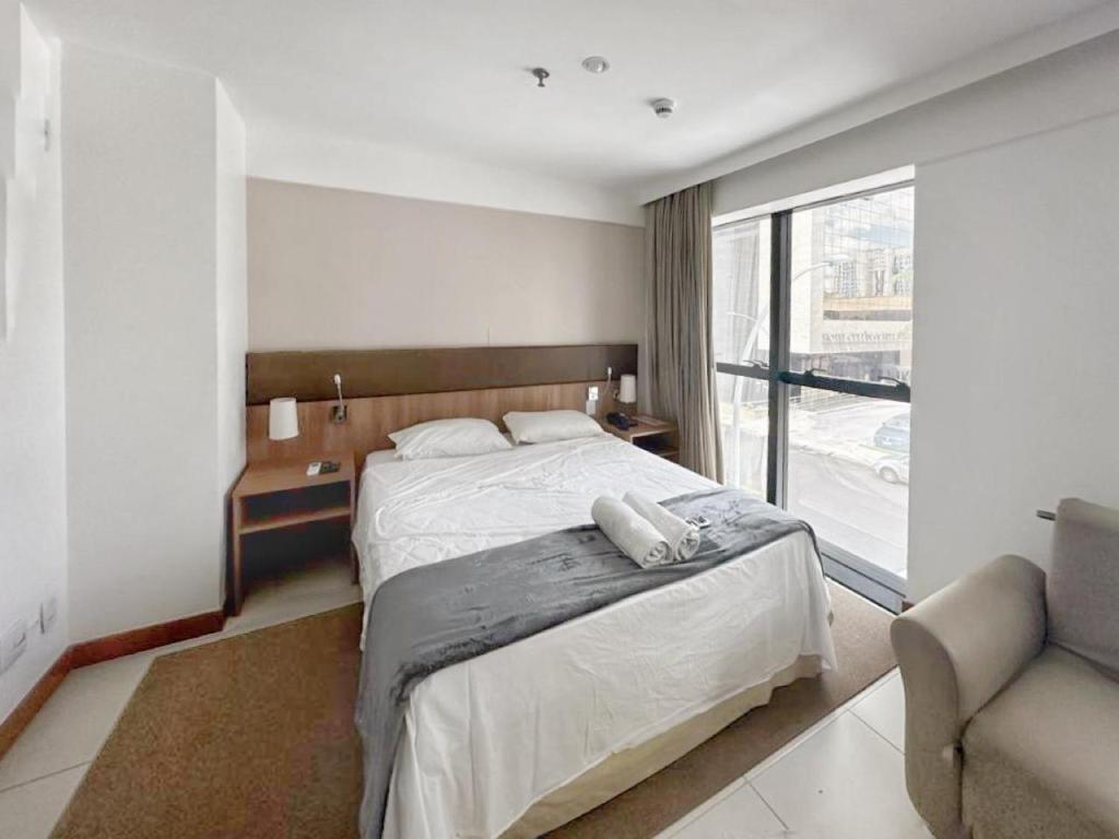 Un dormitorio con una cama y un sofá y una ventana. en Alugueasy - Hotel Athos Bulcão, en Brasilia