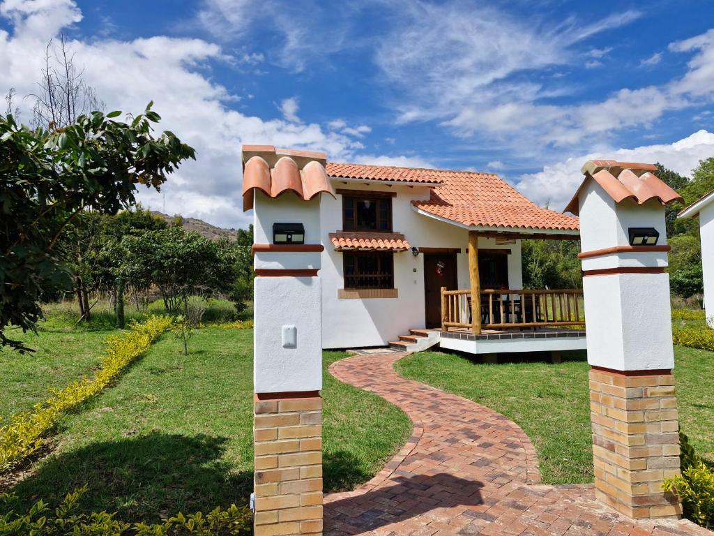 uma casa com dois portões em frente a um quintal em Hospedaje Resguardo Real em Ráquira