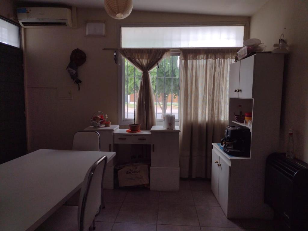 a kitchen with a table and a window and a table and chairs at Portal de la Colonia in Junín
