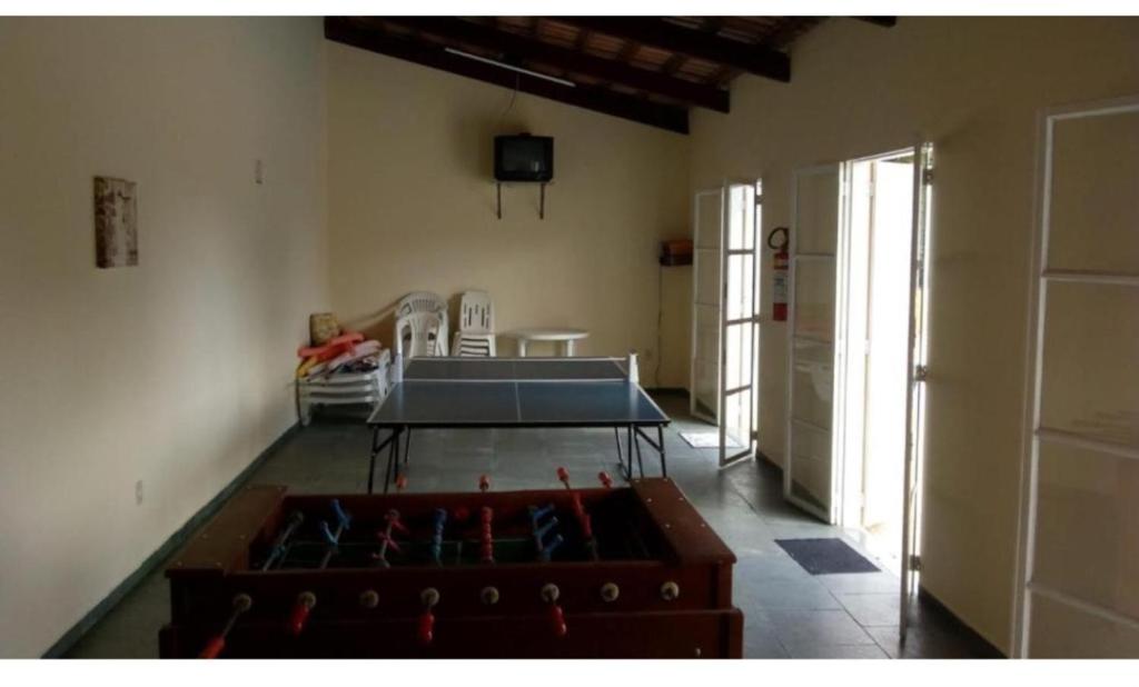 a room with a ping pong table in the middle at Casa Aconchegante em Serra Negra in Serra Negra