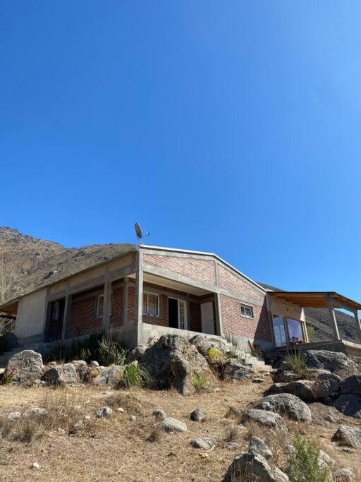 ein großes Backsteinhaus inmitten eines Feldes in der Unterkunft Casa en la montaña con gran vista al valle y lago in El Mollar