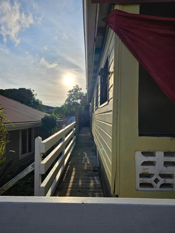 a porch of a house with a fence and the sun at L'Improviste atypique pour une pause détente in Le François