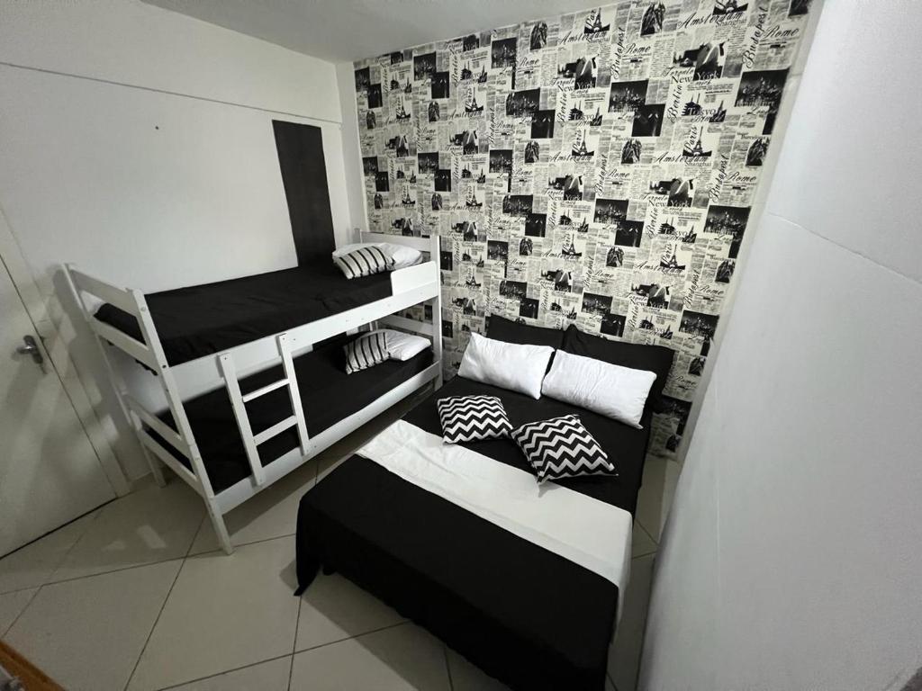 Habitación pequeña con 2 literas y pared en HOSTEL e POUSADA SALVADOR PRAIA, en Salvador