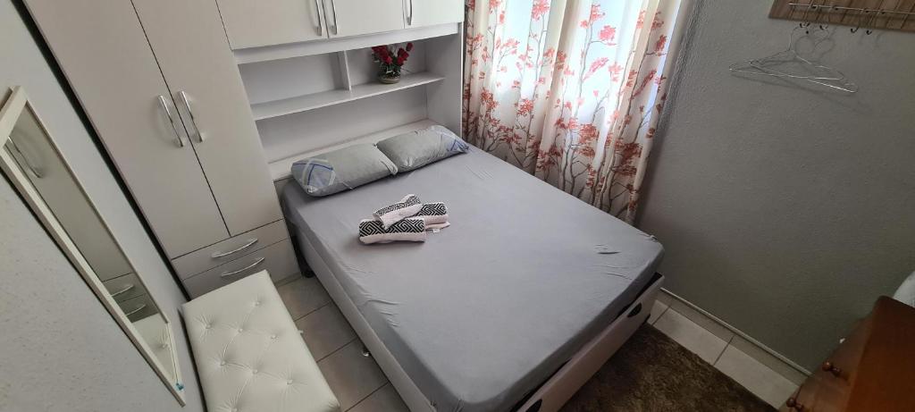 a small bed in a room with shoes on it at Apartamento na Serra in Teresópolis