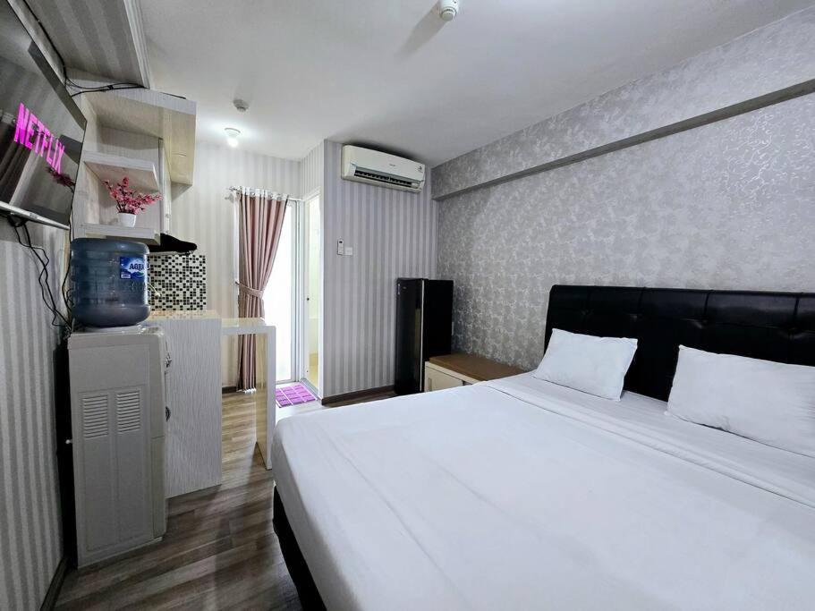 - une chambre avec un grand lit blanc dans l'établissement Apt Bassura Studio Tower F w/ Pool, Wi-Fi & Netflx, à Jakarta
