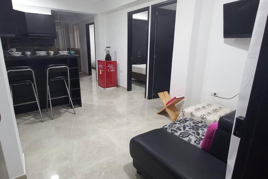 ein Wohnzimmer mit einem Sofa und einer Küche in der Unterkunft Apartamento central y tranquilo in Palmira