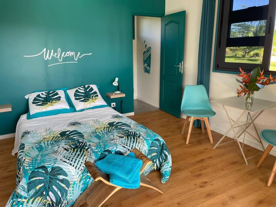a bedroom with a bed with blue walls and a table at Bungalow Tiny House Puunui 