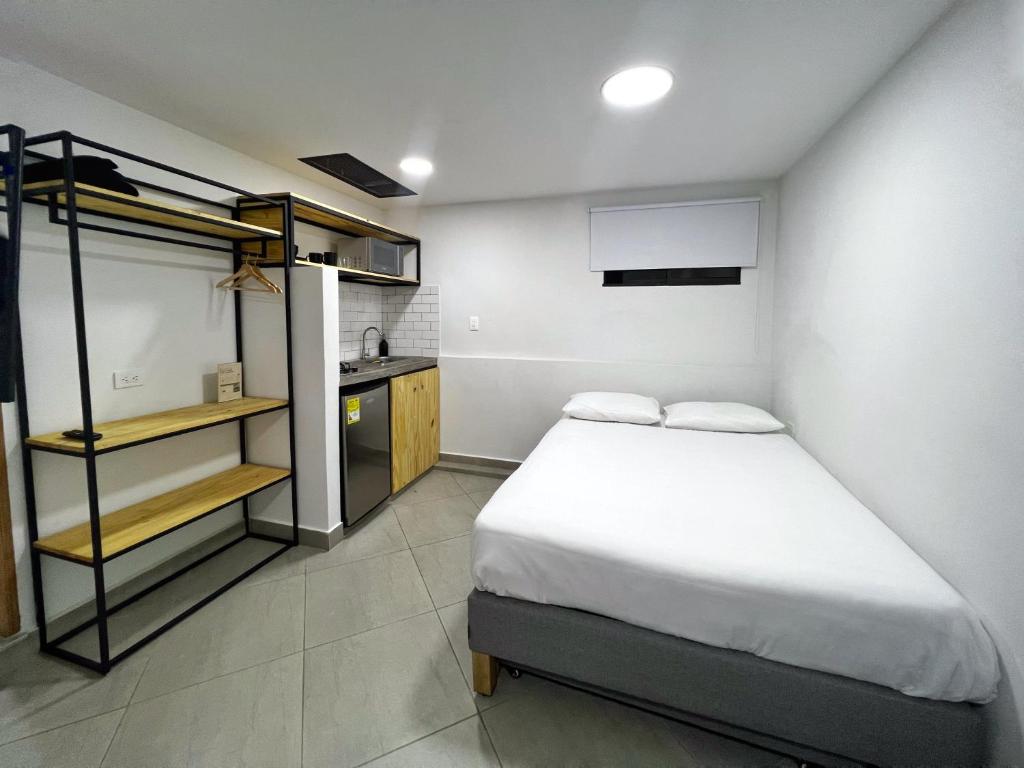 a small bedroom with a bed and a kitchen at Casa hotel Los Laureles in Medellín