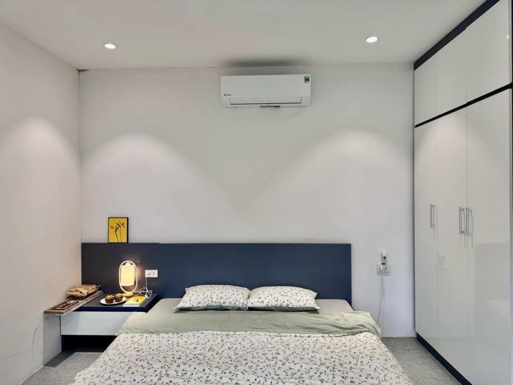 a bedroom with a large bed with a blue headboard at NUhome in Hòa Bình