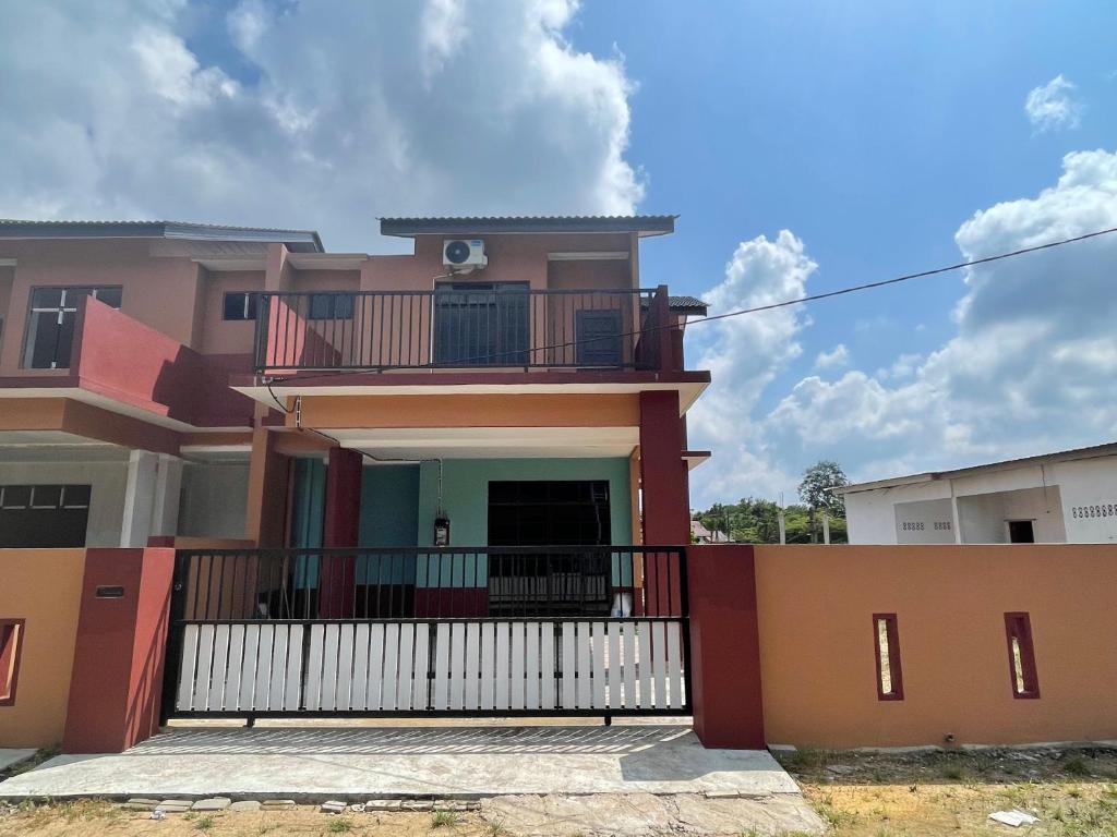 a house with a balcony in front of it at Homestay ZR in Kuala Berang