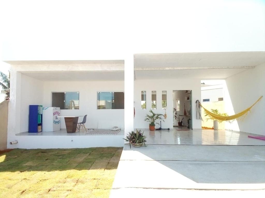 ein weißes Haus mit einer Veranda und einer Terrasse in der Unterkunft Casatriz in Paripueira