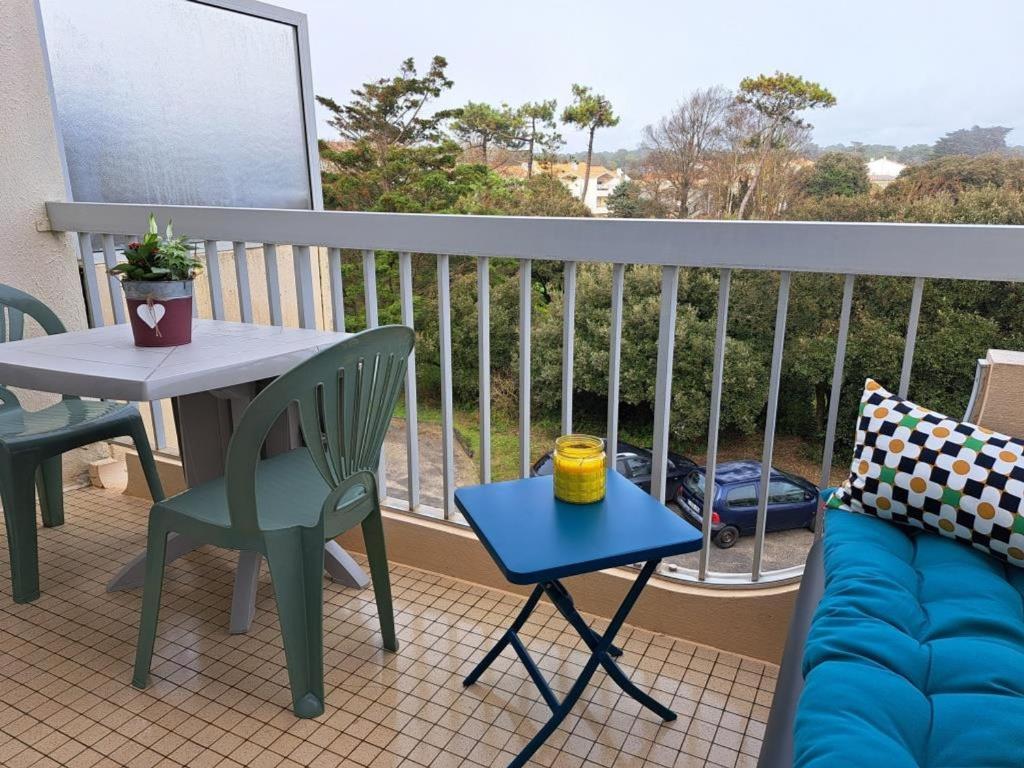 - un balcon avec une table et un canapé dans l'établissement Appartement cosy près de la plage avec balcon, Wi-Fi et parking – Saint-Jean-de-Monts - FR-1-323-508, à Saint-Jean-de-Monts