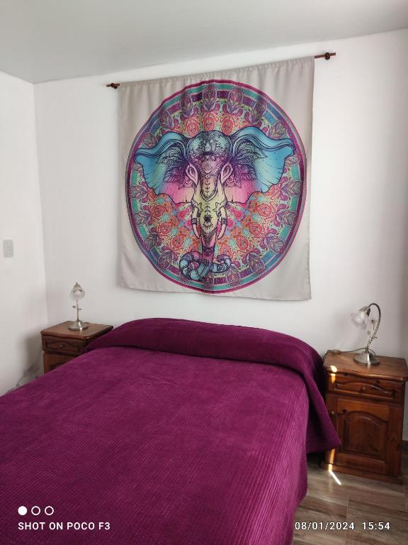 a bedroom with a purple bed with a painting on the wall at Alquimia Qi del Mar in Mar de Cobo