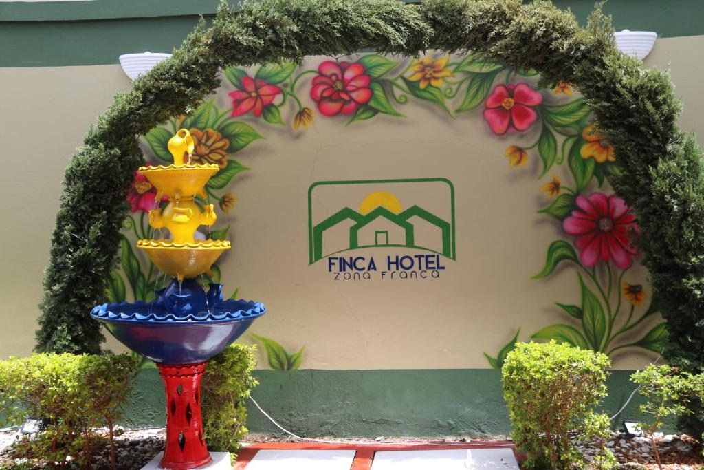 un panneau avec une fontaine devant un bâtiment dans l'établissement Finca Hotel Zona Franca, à Rionegro