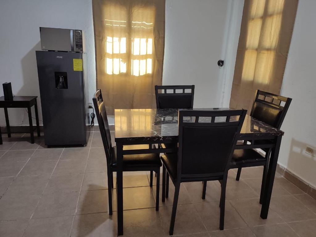 ein Esszimmer mit einem Tisch und Stühlen sowie einem Kühlschrank in der Unterkunft Mi casa in Ciudad Juárez