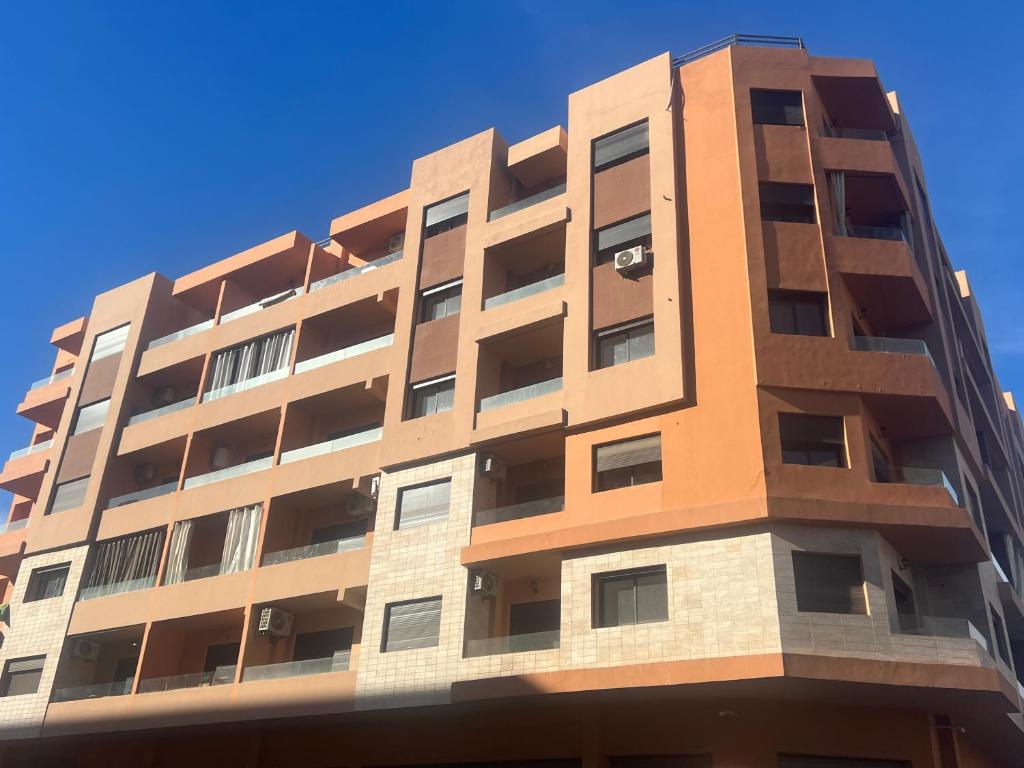 馬拉喀什的住宿－Luxury apartment Gueliz (2 min walk from Train Station)，蓝色天空下方的高公寓