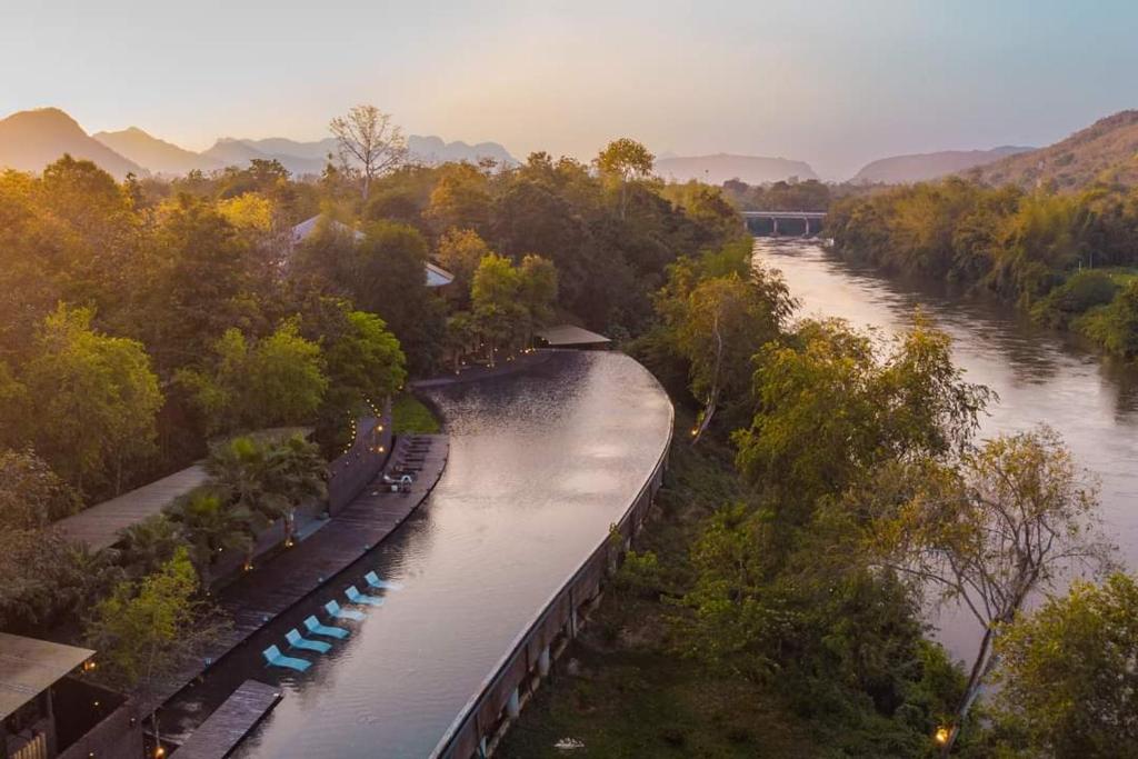 una vista aérea de un río con un tren en él en The Sense Resort Kanchanaburi en Kanchanaburi