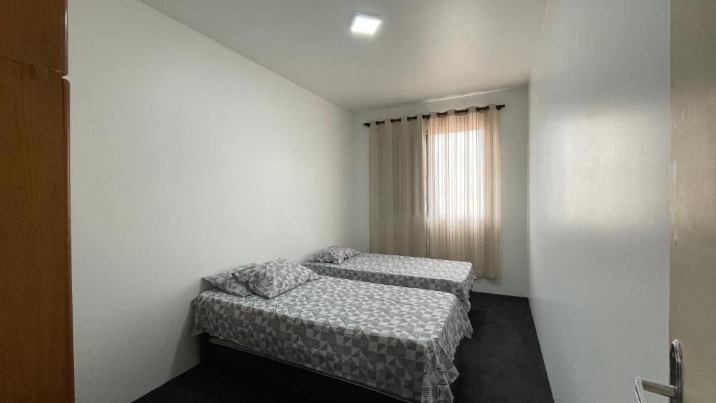 1 Schlafzimmer mit 2 Betten und einem Fenster in der Unterkunft Desativado in São Vicente