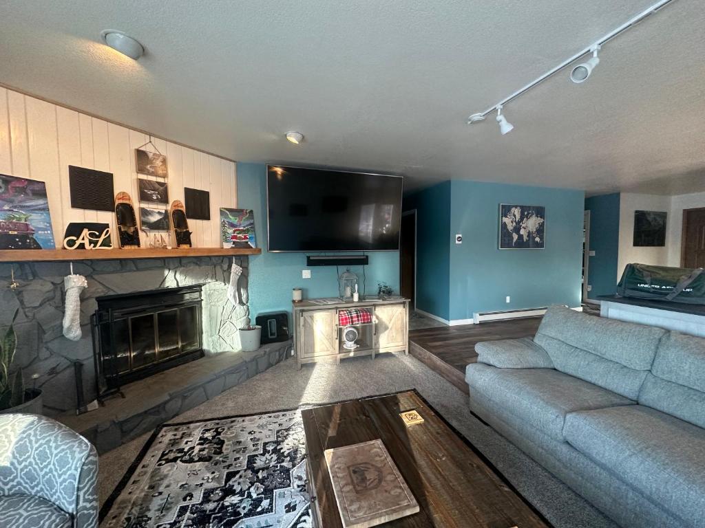 uma sala de estar com um sofá e uma lareira em Hidden Lakefront Villa em Fairbanks