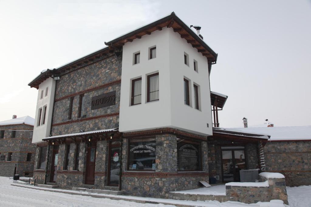 a building with snow on top of it at Arolithos-Kaimaktsalan in Palaios Agios Athanasios