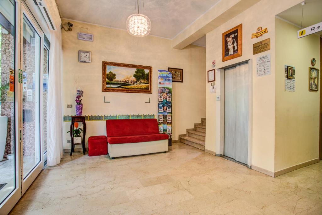 a living room with a red couch and stairs at Hotel Tiziana in Rimini