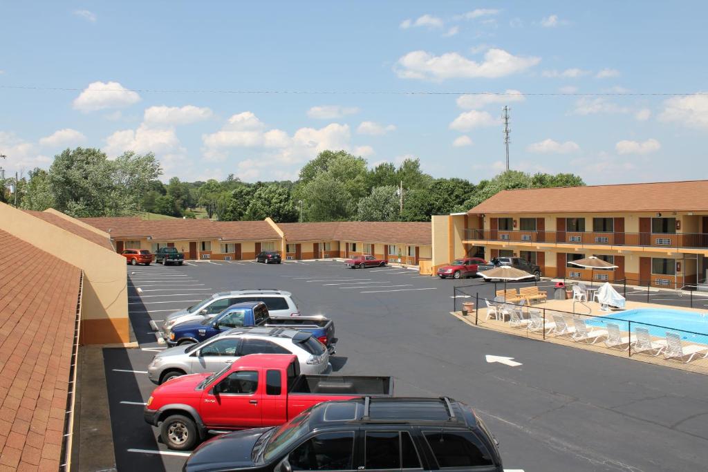 un estacionamiento con autos estacionados frente a un edificio en Andrew Johnson Inn en Greeneville