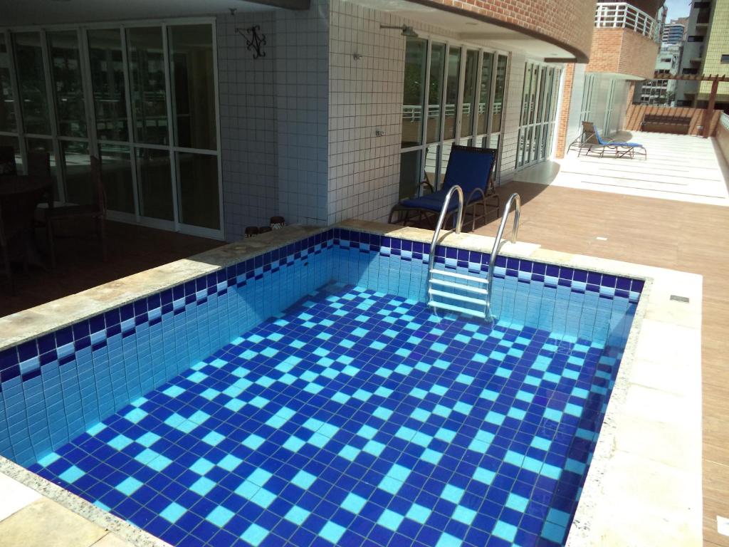 uma piscina com azulejos azuis numa casa em Brisa do Mar Apartments em Fortaleza