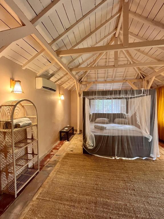 a room with a bed with a mosquito net at Cabana Capybara in Mirissa